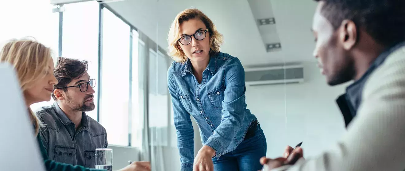 Woman addressing a group around a conference table